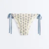 Bikinis-Slip mit mittlerer Bedeckung und seitlichen Bändern aus Häkelstoff mit Wellenmuster Bikinis-Slip mit mittlerer Bedeckung und seitlichen Bändern aus Häkelstoff mit Wellenmuster