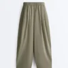 Plissierte, konisch zulaufende Hose aus 100 % Baumwolle Plissierte, konisch zulaufende Hose aus 100 % Baumwolle