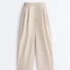 Plissierte, konisch zulaufende Hose aus 100 % Baumwolle Plissierte, konisch zulaufende Hose aus 100 % Baumwolle