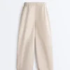 Plissierte, konisch zulaufende Hose aus 100 % Baumwolle Plissierte, konisch zulaufende Hose aus 100 % Baumwolle